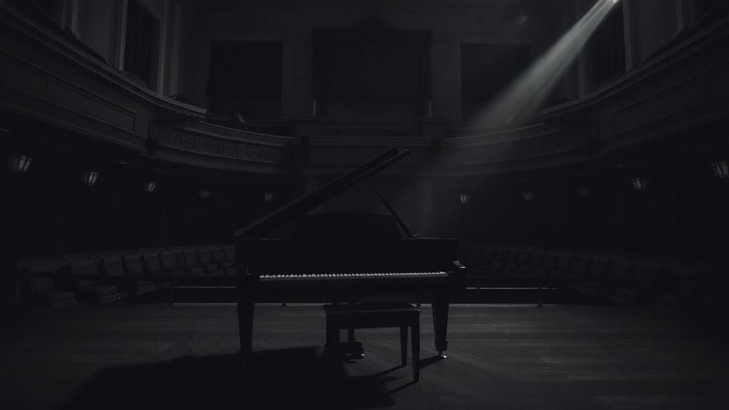 Dark black-and-white grand piano on a concert stage